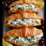 Classic chicken salad filling being spooned into a croissant